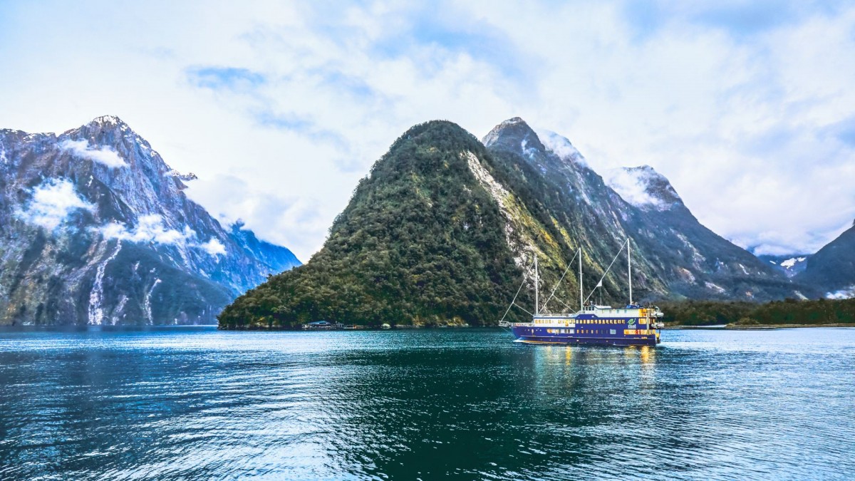 Scenic shot of Milford Sound with a vessel in the distance