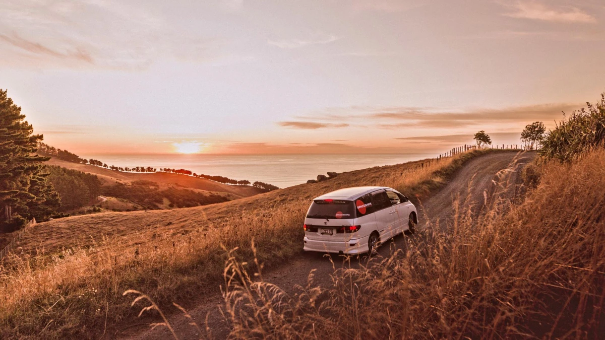 Campervan on a coastal road while the sun is setting