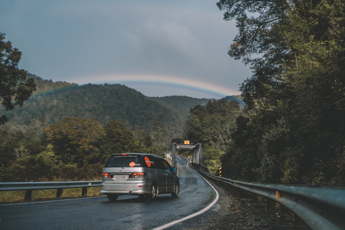 campervan driving on a narrow mountain pass road driving towards a one lane bridge