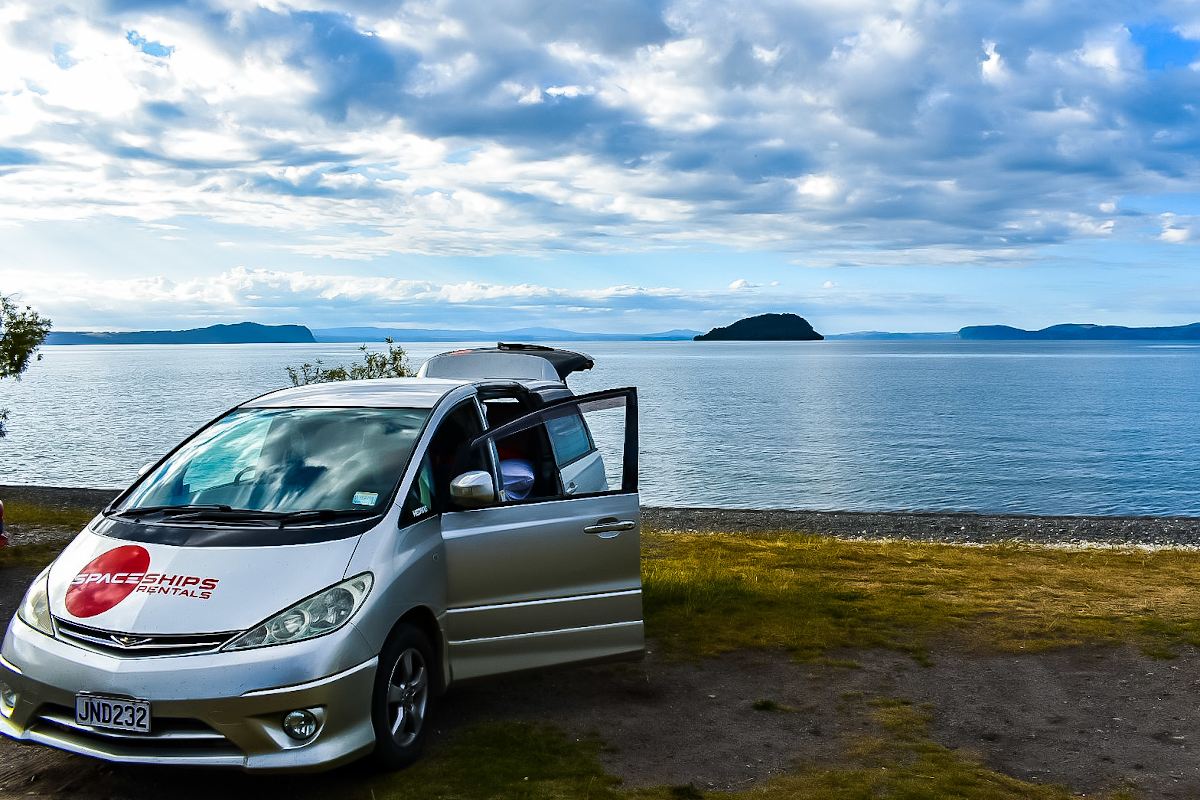 Campervan parked beachside with its door and boot open