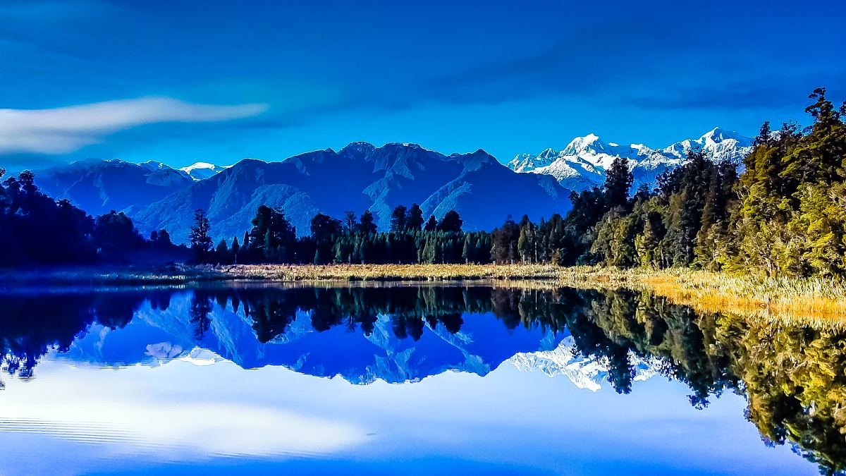 Get up early to snap the best shots of Lake Matheson aka Mirror Lake on your South Island road trip