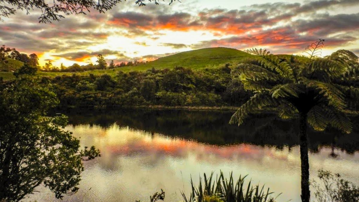 Sun setting behind the green hills of McLaren Falls Park