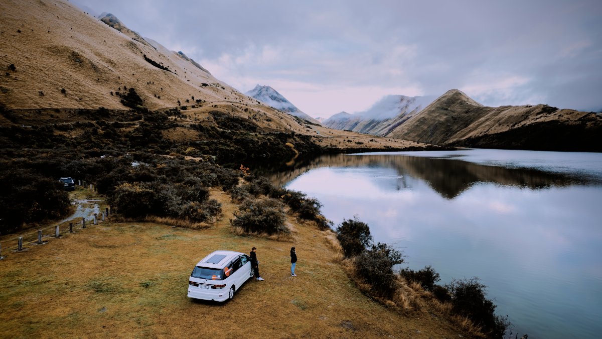 Spaceships Self-Contained Campervan at Moke Lake Campsite - view from above with lake on the right and misty mountains ahead