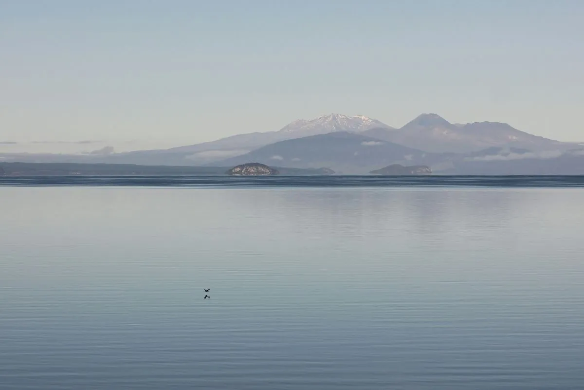 lake with still water and hills in the far background